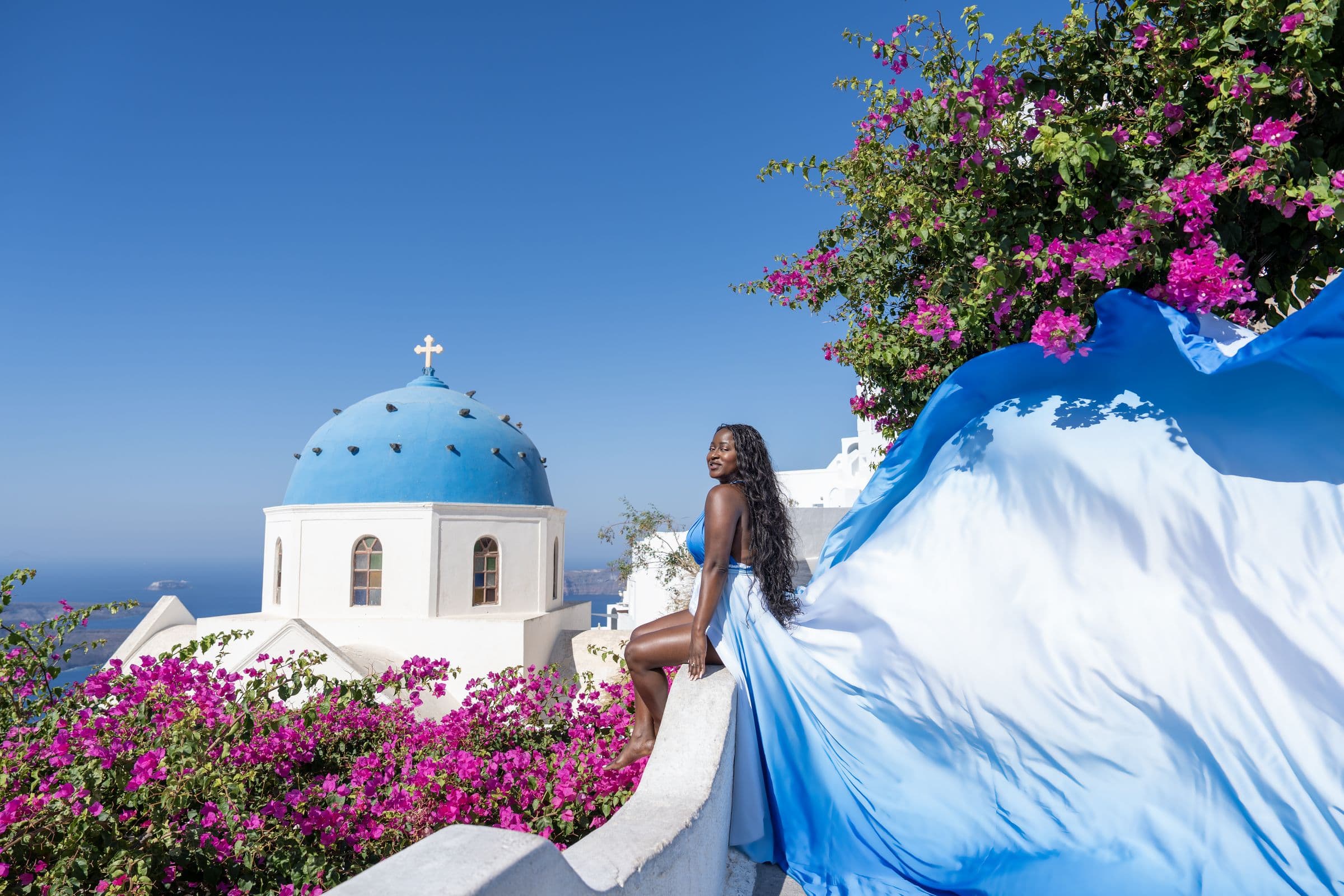 Flying dress session against whitewashed Santorini walls
