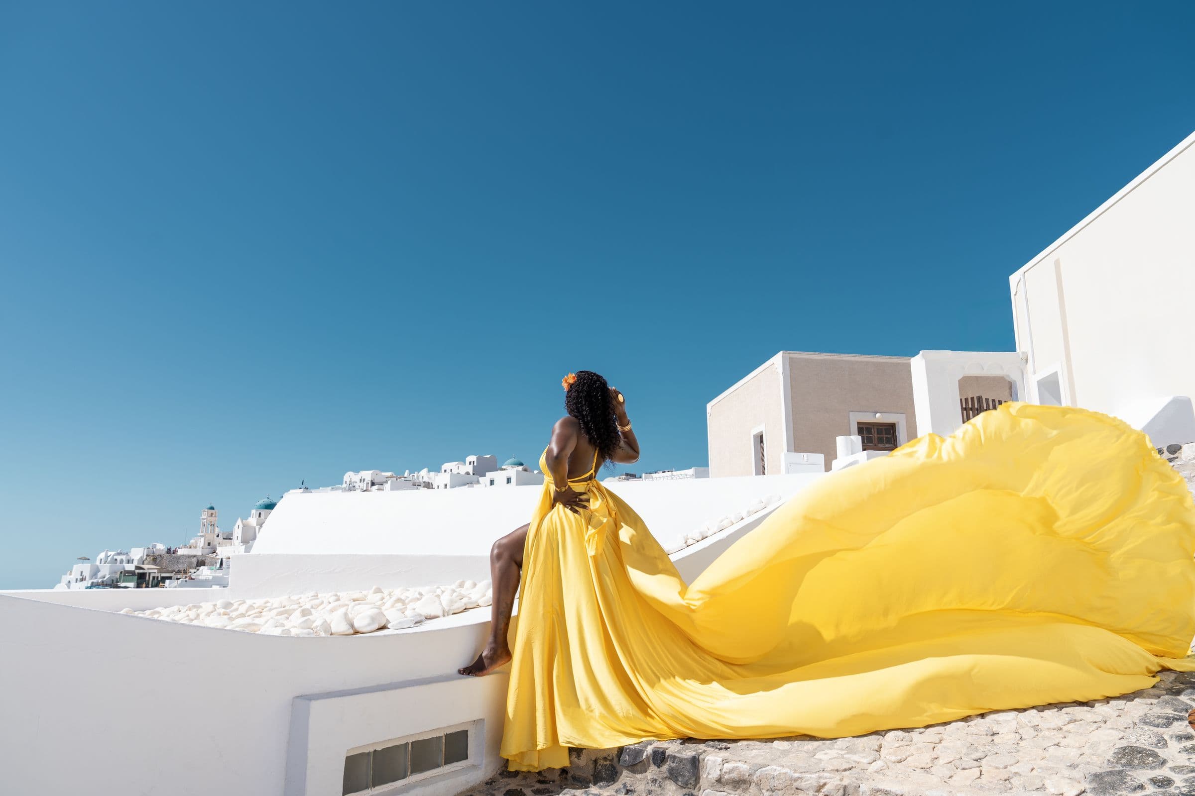 Flying dress session on the cliffs of Santorini at golden hour